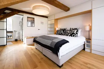 a bedroom with a large white bed with black and white pillows at Les Chambres de Martin in Brussels