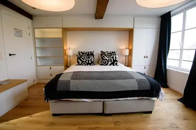a bedroom with a large bed with black and white pillows at Les Chambres de Martin in Brussels