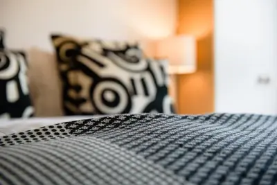 a bed with black and white pillows on it at Les Chambres de Martin in Brussels