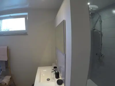 a white bathroom with a sink and a shower at Le Lendemain in Lovendegem