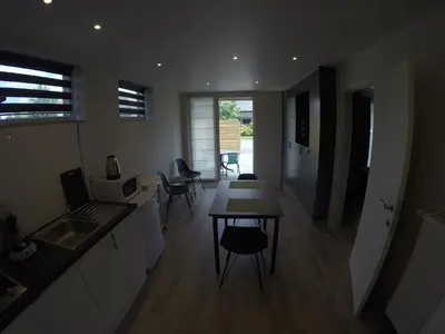 a kitchen and living room with a table and chairs at Le Lendemain in Lovendegem