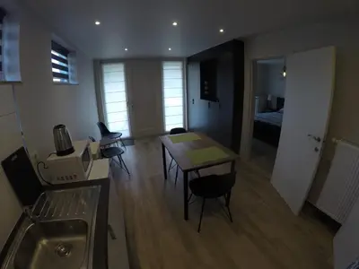 a kitchen and living room with a table and chairs at Le Lendemain in Lovendegem
