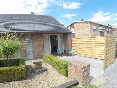 a house with a patio with a table and chairs at Le Lendemain in Lovendegem