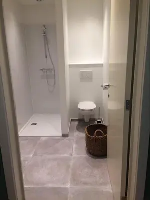 a small bathroom with a toilet and a shower at Le Lendemain in Lovendegem