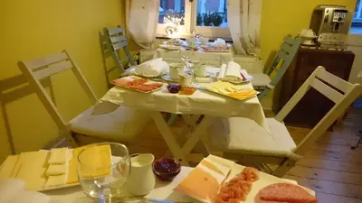 a dining room with a table and chairs with food at B&B La Ducale in Ghent