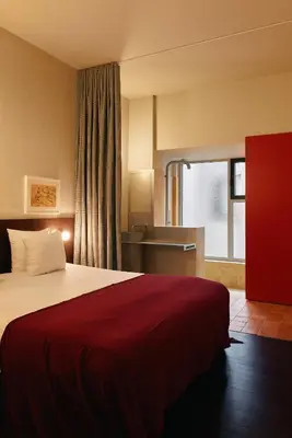 a hotel room with a bed with a red blanket at Hotel Pilar in Antwerp