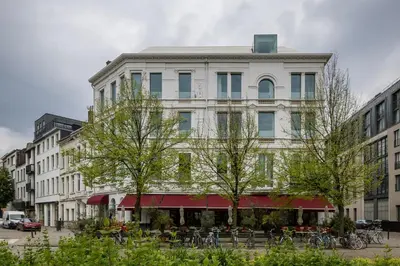 a large white building with trees in front of it at Hotel Pilar in Antwerp