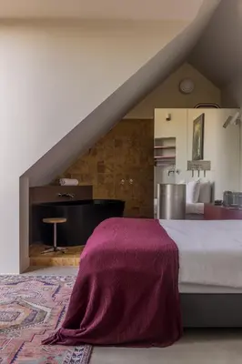a bedroom with a bed with a purple blanket on it at Hotel Pilar in Antwerp