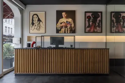 a lobby with a wooden reception desk with pictures on the wall at Hotel Pilar in Antwerp