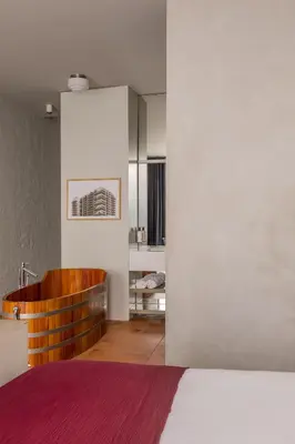 a bedroom with white walls and a bed and a sink at Hotel Pilar in Antwerp