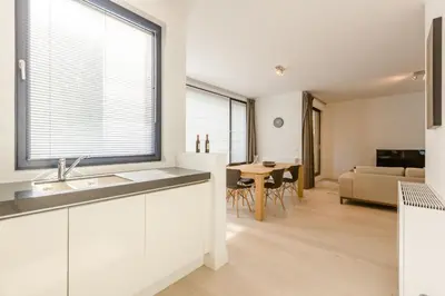 a kitchen and living room with a large window at The Livorno in Brussels