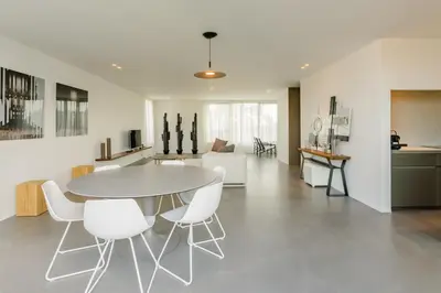 a dining room and living room with a table and chairs at The Livorno in Brussels