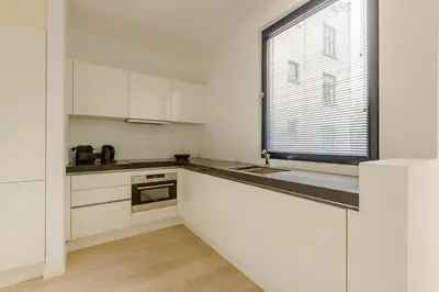 a kitchen with white cabinets and a window at The Livorno in Brussels
