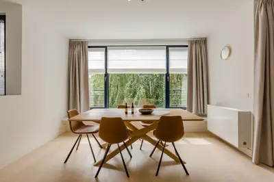 a dining room with a table and chairs and a window at The Livorno in Brussels