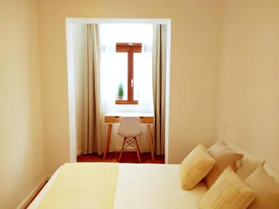 a bedroom with a bed and a window and a desk at De Mot B&B in Brussels