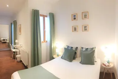 a bedroom with a white bed with green curtains at De Mot B&B in Brussels