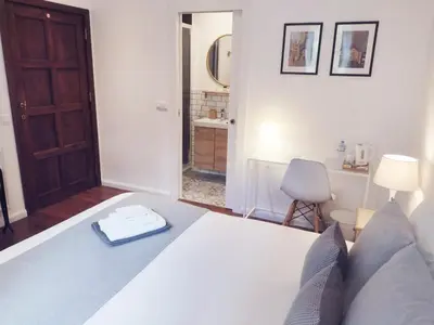 a bedroom with a white bed and a bathroom at De Mot B&B in Brussels