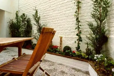 a wooden chair sitting next to a table and some plants at De Mot B&B in Brussels