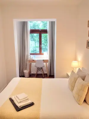 a bedroom with a bed with a desk and a window at De Mot B&B in Brussels