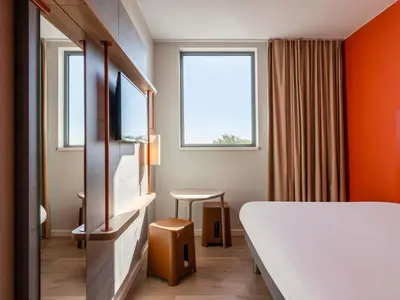 a hotel room with a bed and a window at ibis budget Gent Centrum Dampoort in Ghent
