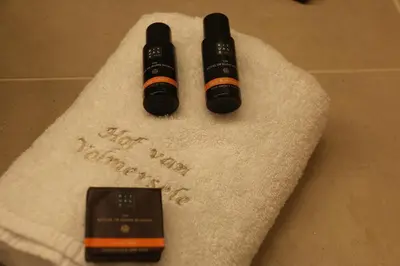 a towel with a cell phone on top of it at Hof Van Volmersele - Luxury B&B in Kampenhout