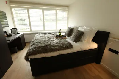 a bedroom with a large bed with a fur blanket at Hof Van Volmersele - Luxury B&B in Kampenhout