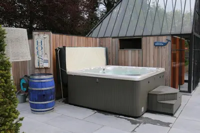a bath tub sitting next to a wooden fence at Hof Van Volmersele - Luxury B&B in Kampenhout