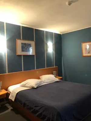 a bedroom with a bed with a blue wall at Hotel In Den Hoek in Tielt