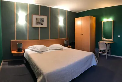 a bedroom with a large bed and green walls at Hotel In Den Hoek in Tielt
