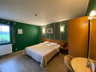 a bedroom with a bed and a green wall at Hotel In Den Hoek in Tielt