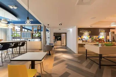 a kitchen and dining room with tables and chairs at Hampton By Hilton Antwerp Central Station in Antwerp