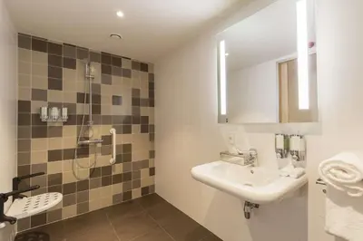 a bathroom with a sink and a shower at Hampton By Hilton Antwerp Central Station in Antwerp