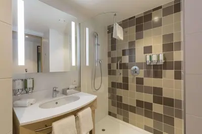 a bathroom with a sink and a shower at Hampton By Hilton Antwerp Central Station in Antwerp
