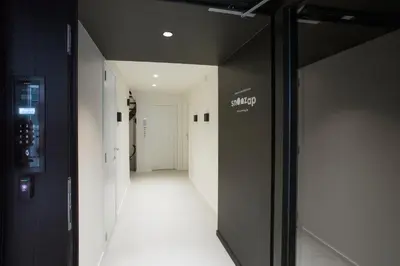a hallway with white walls and a black door at Snooz Ap Holiday & Business Flats in Ghent