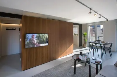 a living room with a tv on a wall at Snooz Ap Holiday & Business Flats in Ghent