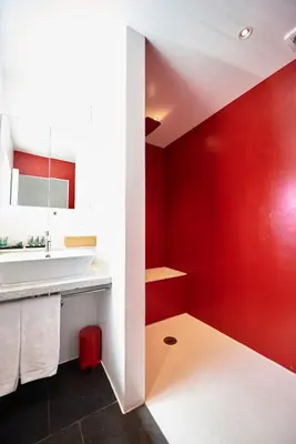 a bathroom with red walls and a white sink at Hotel Colvenier in Antwerp