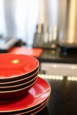 a stack of red plates sitting on top of a counter at Hotel Colvenier in Antwerp