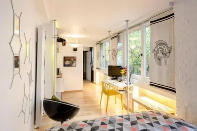 a living room with a black ottoman in a room at BXLROOM Guesthouse in Brussels