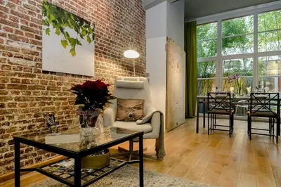 a living room with a brick wall and a table at BXLROOM Guesthouse in Brussels