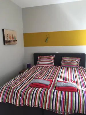 a bedroom with a striped bed with two pillows at Scheldepunt in Ghent