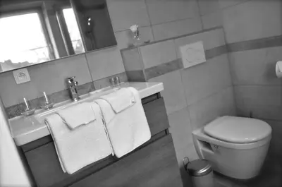 a bathroom with a toilet and a sink with towels at de minnetuin in Wachtebeke