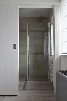 a shower with a glass door in a bathroom at de minnetuin in Wachtebeke