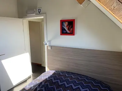 a bedroom with a bed and a painting on the wall at Rap 'n Holiday Home in Sint-Denijs-Westrem