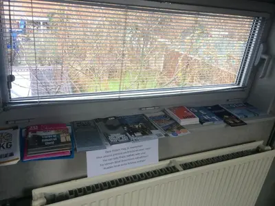 a window with a display of books on a shelf at Rap 'n Holiday Home in Sint-Denijs-Westrem