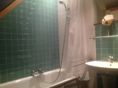 a green tiled bathroom with a shower and a sink at Rap 'n Holiday Home in Sint-Denijs-Westrem