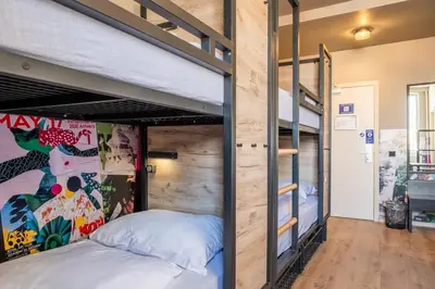 a bedroom with a bunk bed in a room with a wooden wall at a&o Antwerpen Centraal in Antwerp