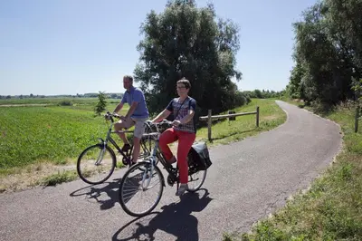a man and a woman riding bikes down a road at B&B De Gilleminus in Temse