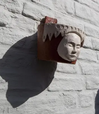 a statue of a head on a brick wall at Sino in Dendermonde