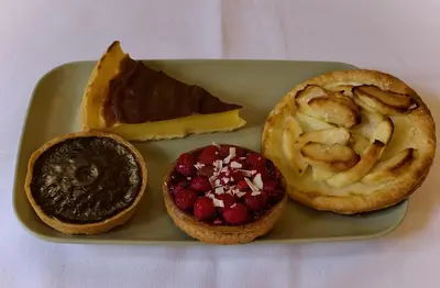 a green plate with three pastries on a table at Hotel Du Parlement in Brussels