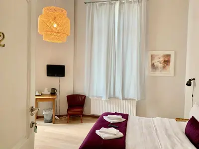 a bedroom with a bed and a chair and a window at Hotel Du Parlement in Brussels